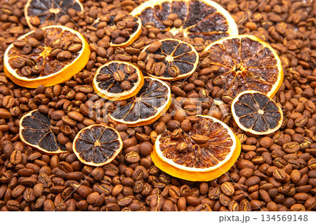 A stunning still life of dried orange slices scattered across roasted coffee beans 134569148