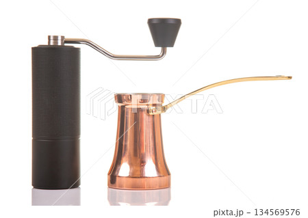 Coffee grinder and cezve positioned for brewing an aromatic coffee blend at home 134569576