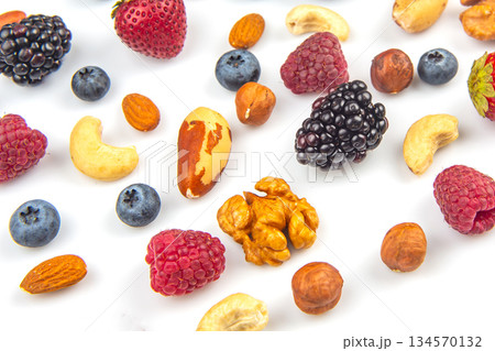 Colorful assortment of fresh fruits and nuts on a white background for healthy snacking Colorful assortment of fresh fruits and nuts on a white background for healthy snacking 134570132