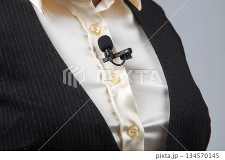 Professional speaker wearing a lapel microphone during an event in a conference setting Professional speaker wearing a lapel microphone during an event in a conference setting 134570145