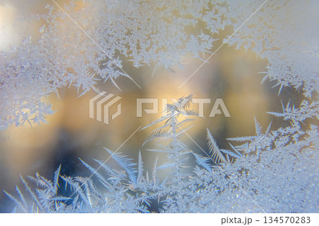 Intricate frost patterns showcase nature's artwork on a chilly window during winter mornings 134570283