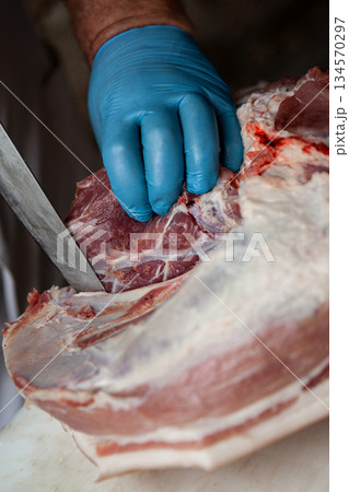 The hand of the professional butcher on the chopping block The hand of the professional butcher on the chopping block 134570297