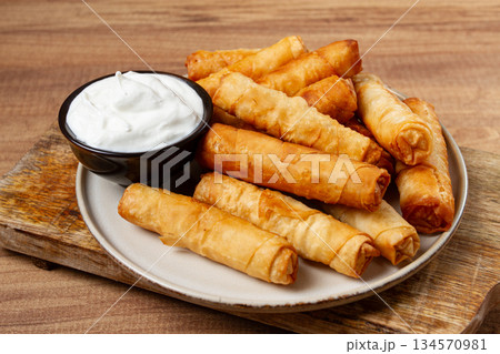 fried spring rolls with cheese, on a wooden background, with cream sauce, no people, fried spring rolls with cheese, on a wooden background, with cream sauce, no people, 134570981