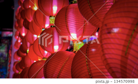 Vibrant red Chinese lanterns glow against a dark night, creating a warm, festive atmosphere perfect for celebrations, festivals, and cultural events. Ideal for mood setting, decoration, and seasonal 134570998