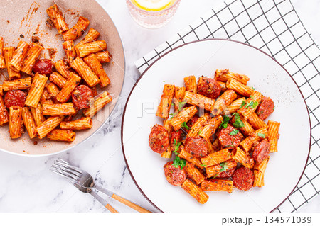 rigatoni pasta with spicy sausage, and rich tomato sauce served, on a white plate, homemade, rigatoni pasta with spicy sausage, and rich tomato sauce served, on a white plate, homemade, 134571039