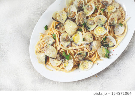 spaghetti with vongole clams, in cream sauce, carbonara, on a white plate, homemade, top view, no people, 134571064