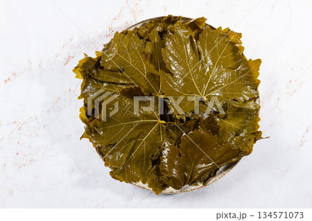 canned grape leaves, for cooking dolma, on a plate, 134571073