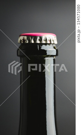 Macro of glass bottle neck with pink crown cap on dark background. High quality photo Macro of glass bottle neck with pink crown cap on dark background. High quality photo 134571080