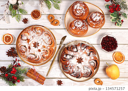 Homemade winter desserts, stollen, rolls, pies, or buns with nuts, cinnamon, cranberries, poppy seeds, and egg liqueur. Festive kitchen banner. Concept for holiday baking, seasonal treats Homemade winter desserts, stollen, rolls, pies, or buns with nuts, cinnamon, cranberries, poppy seeds, and egg liqueur. Festive kitchen banner. Concept for holiday baking, seasonal treats 134571257
