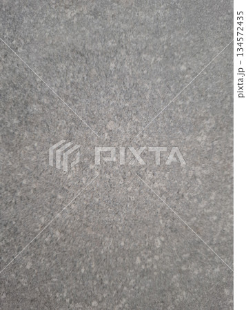 The scene shows a neutral gray background that features subtle patterns and variations in texture. The surface appears even and uniform throughout without any distinct features. 134572435