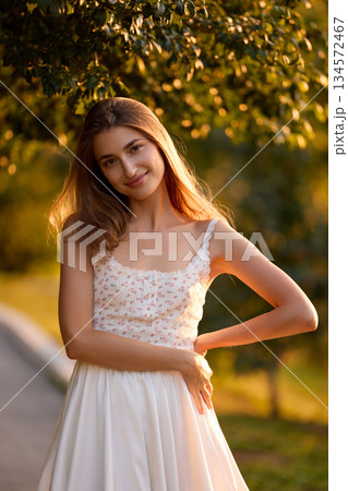 Slavic Woman in Sunlit Garden Wearing White Skirt Slavic Woman in Sunlit Garden Wearing White Skirt 134572467