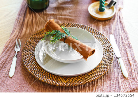 Festive Christmas aesthetic dinning setting with ceramic plates, linen napkin and natural decor 134572554