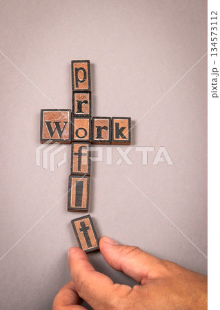 Work and Profit Concept with Wooden Letter Blocks on Gray Background Work and Profit Concept with Wooden Letter Blocks on Gray Background 134573112