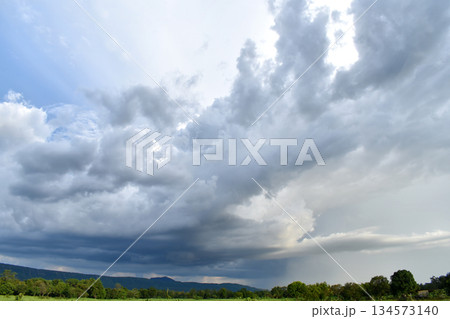 A large cloud from the storm was forming a dark gray rain cloud. over the fields and mountains 134573140