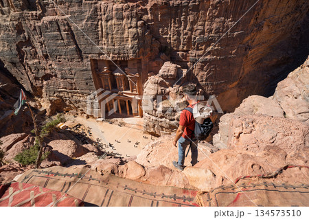 Tourist standing on cliff edge overlooking the Treasury in Petra, Jordan Tourist standing on cliff edge overlooking the Treasury in Petra, Jordan 134573510