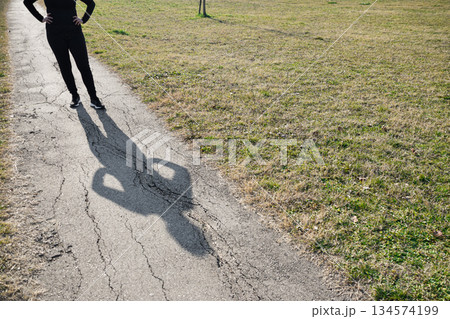 Body of woman projecting her shadow on path expressing Loneliness and Challenges 134574199