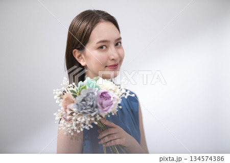 花束を持つ青いブラウスの女性 134574386