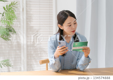 通帳を見る女性 通帳を見る女性 134574888
