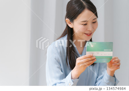 通帳を見て微笑む女性 134574984