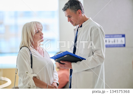 Doctor discusses health concerns with patient in clinic during daylight hours Doctor discusses health concerns with patient in clinic during daylight hours 134575368