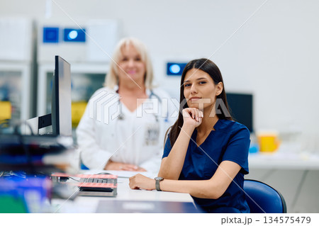 Medical professionals working together in a lab setting during daytime with computers and equipment nearby 134575479
