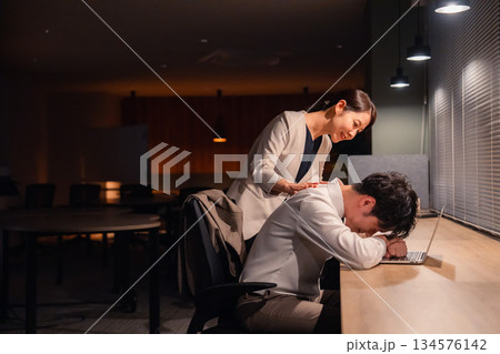 夜遅くまで働く男性とそれを労う女性上司 夜遅くまで働く男性とそれを労う女性上司 134576142