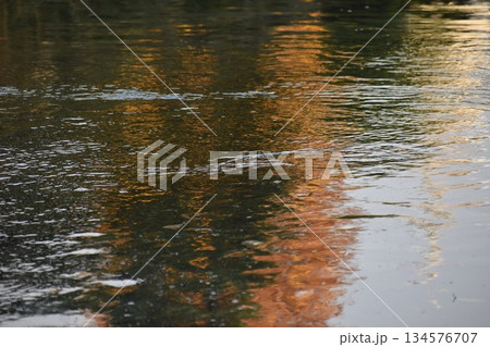 水面に生じるさざ波を基調としたオレンジ系の背景素材 134576707