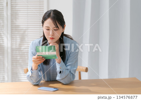 通帳を見て困る女性 通帳を見て困る女性 134576877