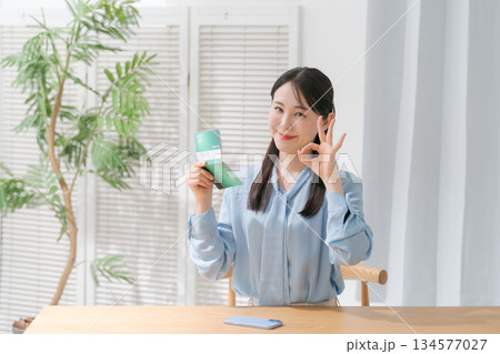 通帳を見て微笑む女性 通帳を見て微笑む女性 134577027