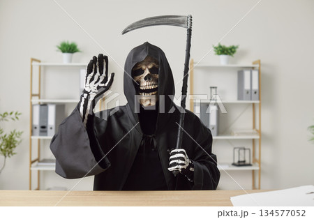 Grim Reaper Waving Hand At Desk In Office Grim Reaper Waving Hand At Desk In Office 134577052
