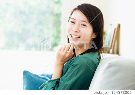 リビングでくつろぐ若い女性 リビングでくつろぐ若い女性 134578006