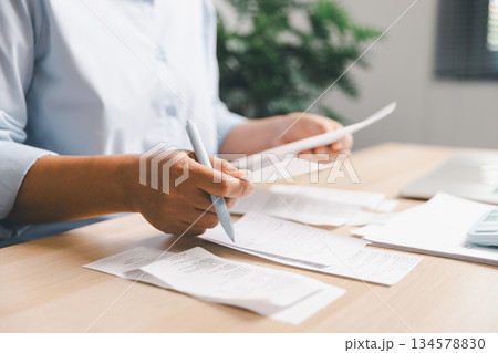 Business person reviewing multiple receipts, expense documents at desk, illustrating financial management, bill checking, budgeting, accounting workflow, cost tracking, daily office financial tasks. Business person reviewing multiple receipts, expense documents at desk, illustrating financial management, bill checking, budgeting, accounting workflow, cost tracking, daily office financial tasks. 134578830