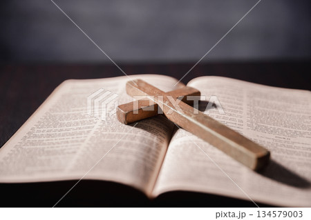 Open Bible on black background. Religion concept. a Christian sat reading an open Bible the holy book of Christianity deepening their faith in God and Jesus Christ, the foundation of their religion. Open Bible on black background. Religion concept. a Christian sat reading an open Bible the holy book of Christianity deepening their faith in God and Jesus Christ, the foundation of their religion. 134579003