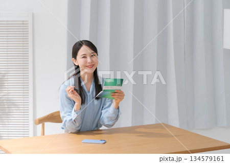 通帳を見て喜ぶ女性 通帳を見て喜ぶ女性 134579161