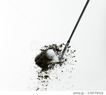 Golf ball explode from Tee off. Golfer hit ball with metal iron club to grass soil explosion on green. Golf club hit ball on green tee off with grass flying scatter. White background isolated Golf ball explode from Tee off. Golfer hit ball with metal iron club to grass soil explosion on green. Golf club hit ball on green tee off with grass flying scatter. White background isolated 134579428