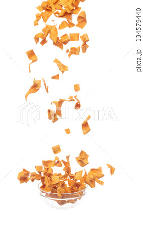 Instant Noodle snack fly explosion, yellow instant noodle snack float explode, abstract cloud fly. Curved dried instant noodles snack splash throwing in Air. White background Isolated 134579440