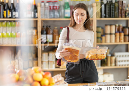 Young woman choosing chicken in grocery store 134579523