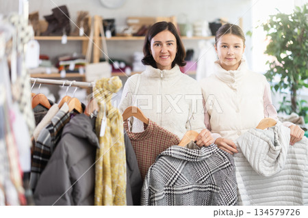 Adult woman and her daughter choosing winter clothes Adult woman and her daughter choosing winter clothes 134579726