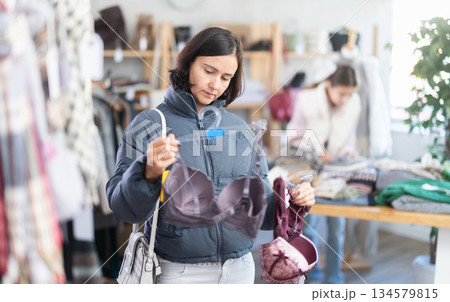 Adult woman chooses underwear in clothing store Adult woman chooses underwear in clothing store 134579815