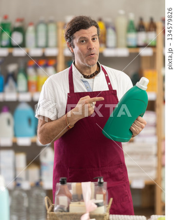 Adult male seller offering laundry detergent Adult male seller offering laundry detergent 134579826