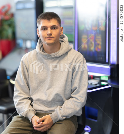 Young man in hall with slot machines Young man in hall with slot machines 134579832