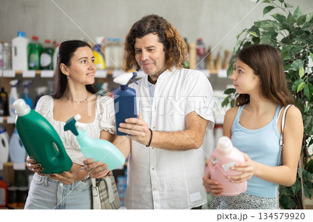 Family choosing laundry detergent in store during summer Family choosing laundry detergent in store during summer 134579920