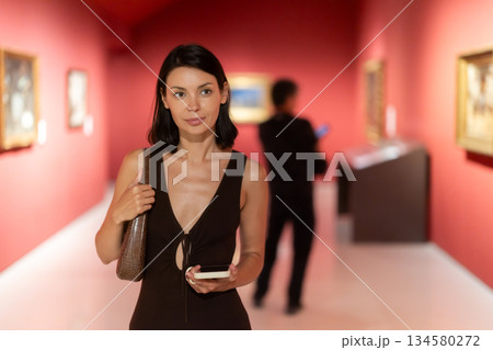 Woman in summer dress standing in art gallery 134580272