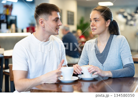 Girl in cafe sits near guy companion, has nice conversation Girl in cafe sits near guy companion, has nice conversation 134580350