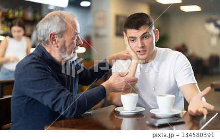 Meeting at cafe, elderly man comforts his son 134580391