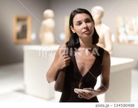 Young woman at a sculpture exhibition Young woman at a sculpture exhibition 134580486