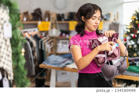 Asian woman chooses underwear or bra in clothing store before Christmas Asian woman chooses underwear or bra in clothing store before Christmas 134580499