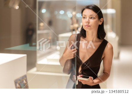 Woman looking at historical exhibits in museum 134580512