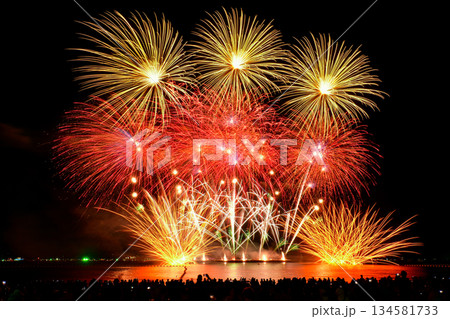Colorful fireworks celebration and the night sky background with crowded people on the beach. Colorful fireworks celebration and the night sky background with crowded people on the beach. 134581733