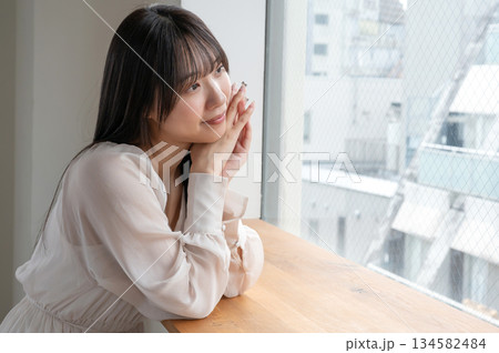窓から外を見る女性 134582484